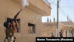 Para kombatan dari Unit Perlindungan Rakyat menembak drone yang dioperasikan militan ISIS di Raqqa, Suriah, 16 Juni 2017. (Foto: Reuters/Goran Tomasevic)