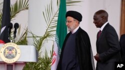 Presiden Iran Ebrahim Raisi (tengah) bersama Presiden Kenya William Ruto memasuki ruangan konferensi pers di Gedung Negara di Nairobi, Kenya, Rabu, 12 Juli 2023. (AP/Khalil Senosi)