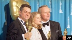 Nan foto sa a (31 me 1992) sineyas Jonathan Demme (agoch) tap resevwa yon twofe pou meyè direktè, ansanm ak aktrès Jodie Foster e aktè Anthony Hopkins. 