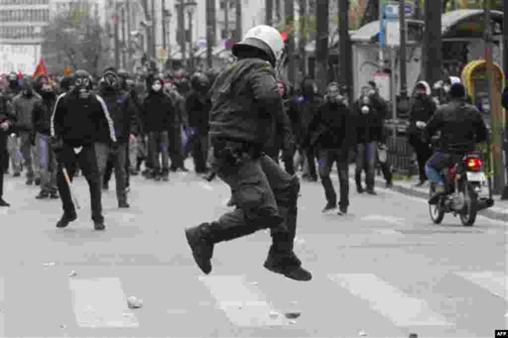 A riot policeman tries to avoid a stone thrown by a protester during clashes in Athens, Friday, Feb. 10, 2012. Thousands took to the streets of Athens as unions launched a two-day general strike against planned austerity measures on Friday, a day after Gr