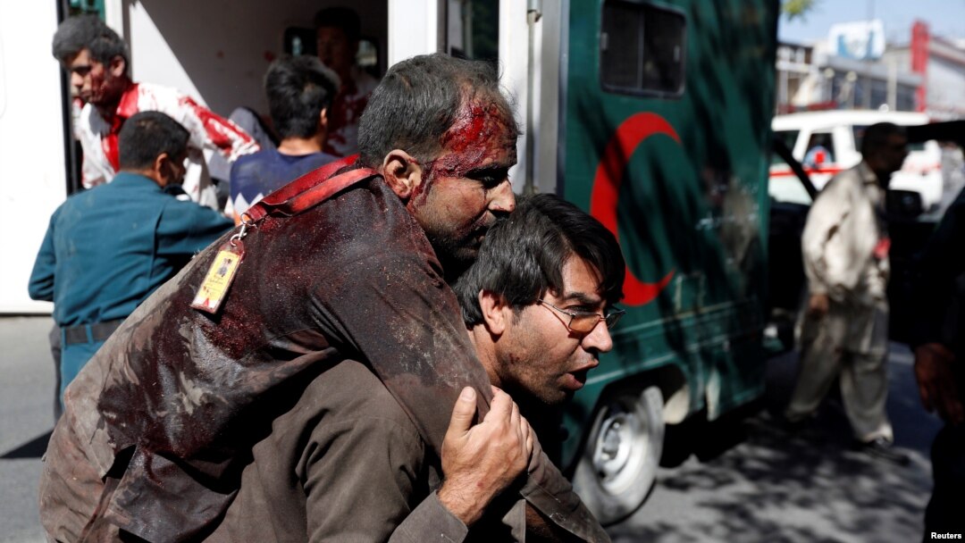 An Afghan man carries an injured man to a hospital after a blast in Kabul, Afghanistan, May 31, 2017. 