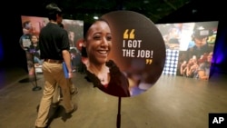 FILE - Job seekers walk into the Opportunity Fair and Forum employment event in Dallas, May 19, 2017. The U.S. Labor Department says the number of newly-laid off workers signing up for assistance fell 8,000 last week to a nationwide total of 237,000.