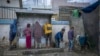 FILE - Palestinian children collect water in jerrycans at a camp for displaced people in Deir al-Balah, Gaza Strip, Dec. 12, 2024.