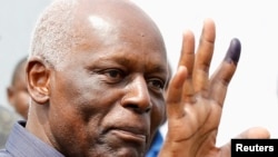 Le président José Eduardo dos Santos montre son doigt marqué de l’encre indélébile après avoir voté à Luanda, Angola, 31 août 2012.