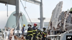 Rescatistas italianos buscan personas en las ruinas de una edificación colapsada por el movimiento telúrico.