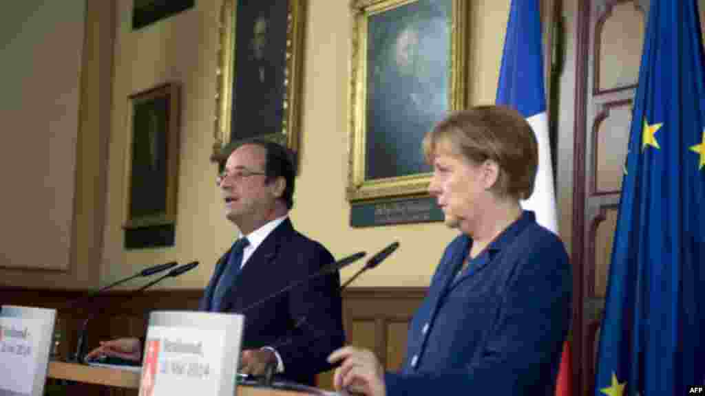 Fransiya Prezidenti Fransua Olland (chapda) hamda Germaniya kansleri Angela Merkel Rossiyaga qarshi yangi jazo choralari e&#39;lon qilinishi mumkinligi haqida ogohlantirmoqda, Shtralzund, Germaniya, 10-may, 2014-yil.