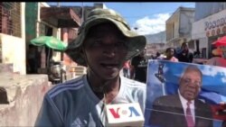 A protester in the Solino neighborhood of Port au Prince holds a photo of Supreme Court Justice Joseph Mécène Jean Louis. (VOA/Matiado Vilme)