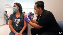 A Florida International University student receives the Pfizer COVID-19 vaccine, April 15, 2021, in Miami.