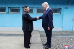 FILE - U.S. President Donald Trump shakes hands with North Korean leader Kim Jong Un as they meet at the demilitarized zone separating the two Koreas, in Panmunjom, South Korea, June 30, 2019.