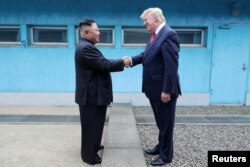 FILE - U.S. President Donald Trump shakes hands with North Korean leader Kim Jong Un as they meet at the demilitarized zone separating the two Koreas, in Panmunjom, South Korea, June 30, 2019.