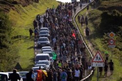 Anti-G-7 activists march along a road near a tent camp near Hendaye, France, Aug. 23, 2019.