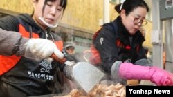 3일 청주시 상당구 서문시장 삼겹살거리에서 열린 '삼겹살데이 무료시식회'에 참여한 자원봉사자들이 삼겹살을 굽고 있다.