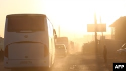 Des bus transportant les combattants de Jaish al-Islam et leurs familles, originaires de Douma, l'ancienne ville du bastion rebelle, arrivent dans la ville syrienne d'Azaz, en route vers un camp de réfugiés, le 5 avril 2018.