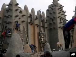 FILE—Malians take part in the annual replastering of the Great Mosque of Djenne, Mali, May 12, 2024.