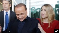 Silvio Berlusconi, président de l’AC Milan, accompagné de sa fille Barbara, signe des autographes pour des supporters au quartier général de son club, à Milan, Italie, 3 juillet 2015. 