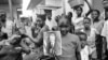 FILE - A girl holds a portrait of US President Jimmy Carter in a market in Lagos, Nigeria, March 31, 1978, the day of his arrival for a state visit, the first to Africa by an American president. 