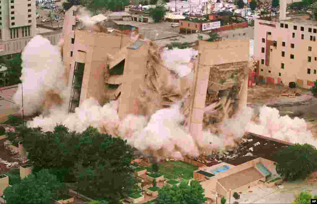 FILE - In this May 23, 1995 file photo, the Alfred P. Murrah Federal Building in downtown Oklahoma City falls in a cloud of dust as it was demolished by exposives. The building was the site of a deadly car-bomb attack April 19, 1995. 
