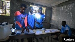 Electoral workers count the votes during a presidential runoff in Freetown, Sierra Leone, March 31, 2018.