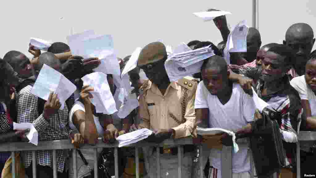 Masu neman aiki sun shiga fafitikar neman aiki da Hukumar Shige da Fici a Abuja ranar 15 ga watan Maris shekarar 2014.