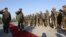 FILE - General Sher Mohammad Karimi, chief of staff of the Afghan army, second left, salutes soldiers during a ceremony in Laghman province, east of Kabul, Afghanistan, Jan. 11, 2015.