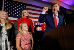 Republican Gov.-elect Tate Reeves addresses his supporters at a state GOP election night event, as wife, Elee Reeves, rear, and daughters listen, Tuesday, Nov. 5, 2019, in Jackson, Miss.