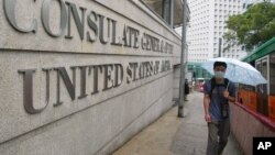 A man wearing a mask to protect himself from catching a deadly pneumonia-like virus walks past the US consulate.