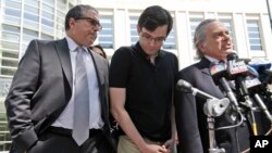 FILE - Martin Shkreli, center, stops with his attorneys to talk to reporters in front of federal court in New York, Aug. 4, 2017. 