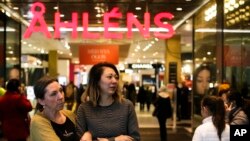 People exit and enter the reopened department store Ahlens in Stockholm, Sweden, April 10, 2017. 