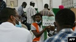 Workers of the Independent Electoral Commission (IEC) count ballots after the closure of the polling stations during the legislative elections, in Abidjan, on March 6, 2021. 