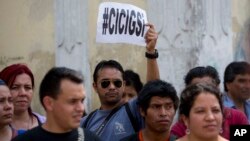 A man holds up a sign that reads in Spanish: "CICIG yes" in reference to the U.N. International Commission Against Impunity, or CICIG, during a protest against Guatemala's President Otto Perez Molina in Guatemala City, April 20, 2015. 