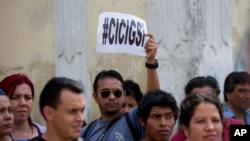 FILE - A man holds up a sign that reads in Spanish: "CICIG yes" in reference to the U.N. International Commission Against Impunity, or CICIG, during a protest against Guatemala's President Otto Perez Molina in Guatemala City, April 20, 2015. 