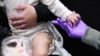 Sherry Andrews, right, holds 13-month-old Jaqi Herrera’s hand after administering the first MMR vaccine dose to Herrera at the City of Lubbock Health Department in Lubbock, Texas, Feb. 27, 2025. 