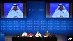 UN Convention on Climate Change Executive Secretary Christiana Figueres, second left, speaks during a press conference alongside Qatar's Deputy Prime Minister and president of the 18th United Nations Convention on Climate Change, Abdullah bin Hamad Al-Attiyah, second and on screens in Doha, Qatar, Dec. 3, 2012.