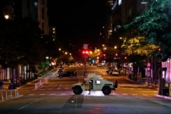 A military Humvee blocks an intersection along K Street in downtown Washington as demonstrators protest the death of George Floyd, Monday, June 1, 2020, in Washington. Floyd died after being restrained by Minneapolis police officers. (AP Photo/Alex…