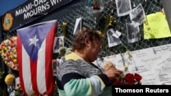 Maria Perdomo grieves by a makeshift memorial for the victims of the Surfside's Champlain Towers South condominium collapse in Miami, July 8, 2021.