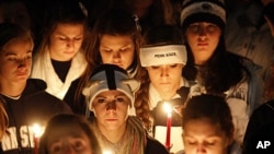 Pennsylvania State University students hold candles during a vigil to show their support for sexual abuse victims involved in the recent controversy at their school, November 11, 2011.