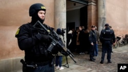 FILE - Heavily armed police officers stand in front of Copenhagen City Court, March 10, 2016, in Copenhagen, Denmark. 