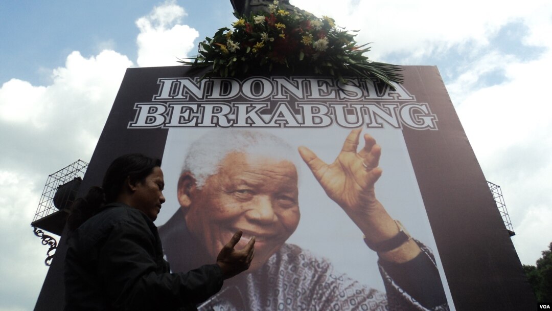Warga Solo membawa papan tanda ikut berkabung atas meninggalnya Nelson Mandela (6/12). (VOA/Yudha Satriawan)