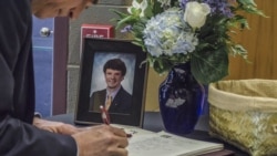 지난 2017년 6월 22일 미국 오하이오주 와이오밍의 와이오밍고등학교에서 열린 오토 웜비어 씨의 장례식에서 조문객이 웜비어 씨의 사진 옆에 놓인 방문객에 이름을 적고 있다.