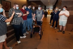 COVID-19 patient Stephen Donelson is applauded by family and health care professionals as he departs the Zale Hospital on the UT Southwestern Campus in Dallas, June 19, 2020.
