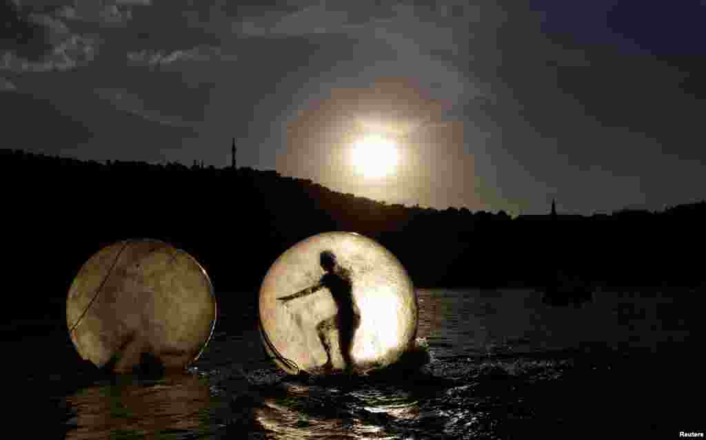 People play inside giant plastic balls, called Zorbs, on the Vltava river in Prague, Czech Republic.