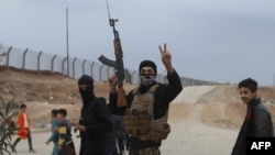 A Syrian Kurdish fighter flashes the V-sign for victory as local gunmen control the area around Qamishli's airport in northeastern Syria on Dec. 8, 2024