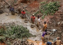 FILE - Men work at Makala gold mine camp near the town of Mongbwalu in Ituri province, eastern Democratic Republic of Congo, April 7, 2018.