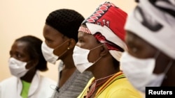 FILE - Patients with tuberculosis (TB) and HIV wear masks while awaiting consultation at a clinic in Cape Town's Khayelitsha township, South Africa.