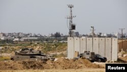 Sebuah tank Israel dan kendaraan militer di pembatas keamanan dekat perbatasan antara Israel dan Jalur Gaza, Israel, 18 Maret 2018. (Foto: Reuters)