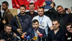 Pemimpin Komisi Pemilihan yang disebut sebagai Republik Warga Donetsk, Denis Pushilin (tengah, depan) dalam konferensi pers di gedung pemerintah yang mereka kuasai di Donetsk, Ukraina (8/5). Militan pro-Rusia memutuskan untuk tetap melaksanakan pemungutan suara untuk mereferendum otonomi wilayah tersebut hari Minggu, meskipun Presiden Rusia merekomendasikan agar menundanya.