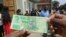 FILE- A man holds one of the new two-dollar banknotes issued by the Reserve Bank of Zimbabwe in Harare, Tuesday, Nov, 12, 2019. 