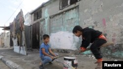 Palestinian children play outside their house in a refugee camp in Gaza City, Gaza Strip.