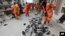 Afghan Municipality workers collect shoes of victims in front the Baqir-ul Ulom mosque after a suicide attack, in Kabul, Afghanistan, Nov. 21, 2016. 