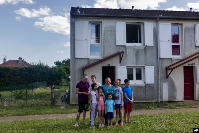 Olga Lopatkina and her children pose for a photo in front of their house in Loue, western France, Saturday, July 2, 2022. (AP Photo/Jeremias Gonzalez)